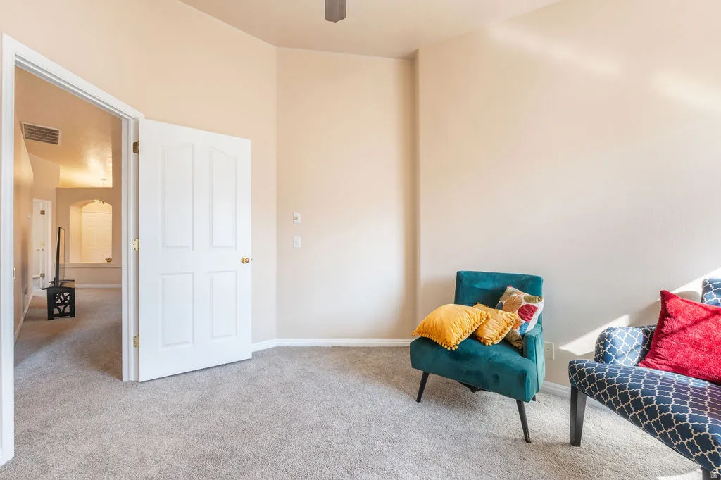 Carpeted flooring, vaulted ceiling, white paneled door, and neutral wall paint