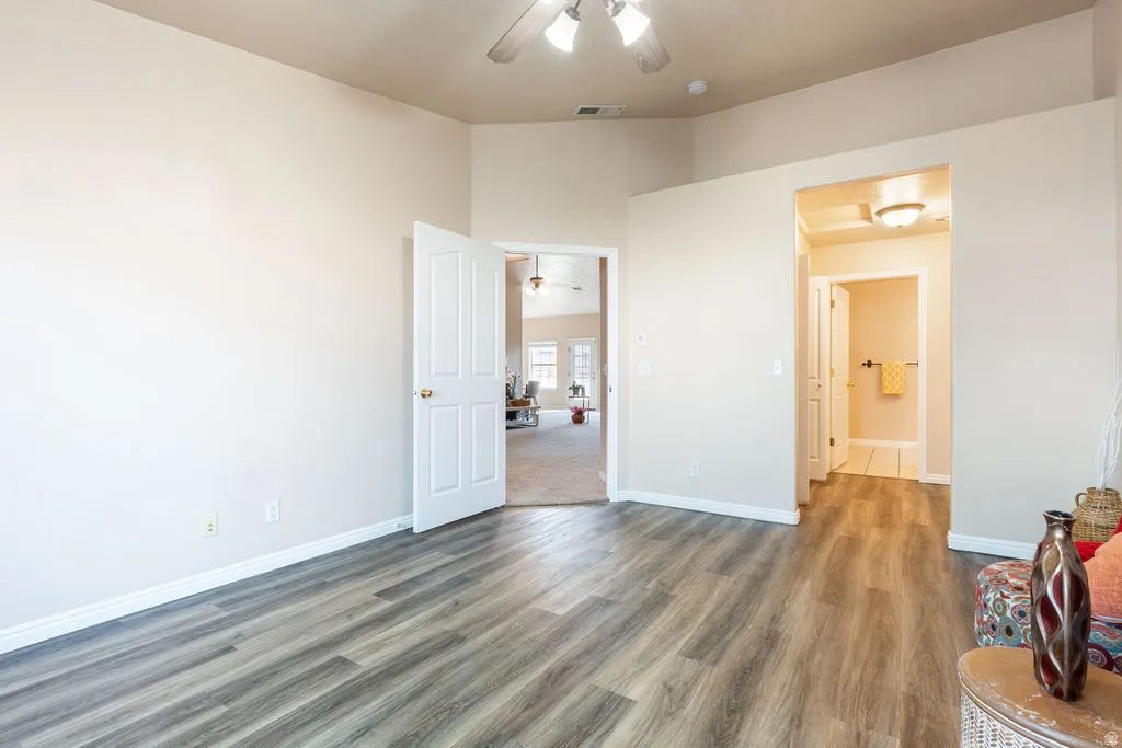 Wood-finish flooring with vaulted ceilings, recessed lighting, and a ceiling fan