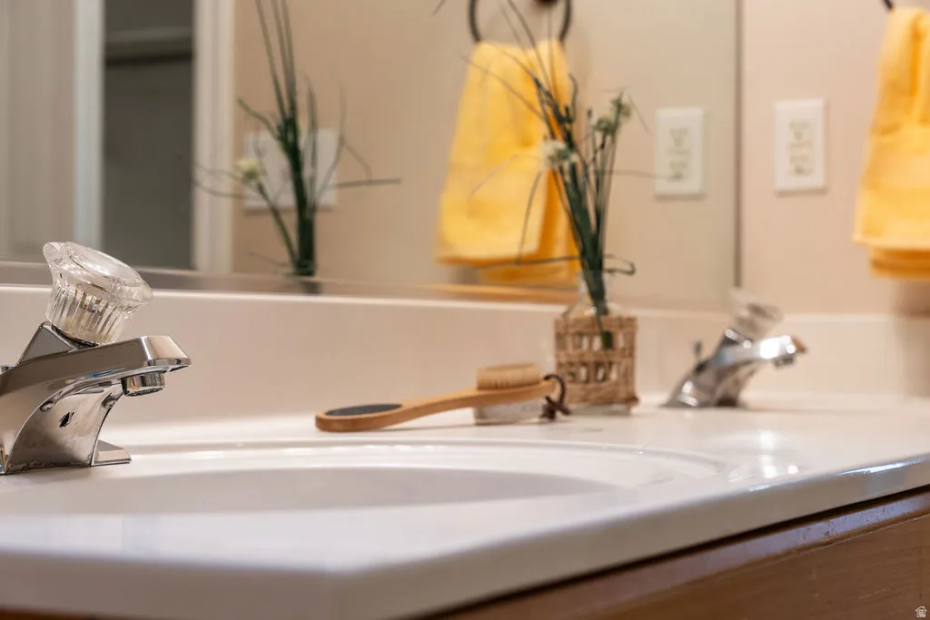 Dual basin vanity featuring a laminate countertop, chrome faucets, and integrated sinks