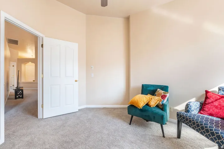 Carpeted flooring, vaulted ceiling, white paneled door, and neutral wall paint