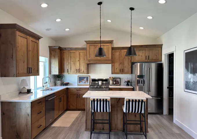 Vaulted ceiling featuring recessed lighting, wood-finish cabinetry, stainless steel appliances, white countertops, and a kitchen island with pendant lighting