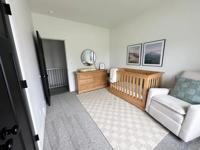 Light-colored walls, dark-stained interior doors, and gray carpeting