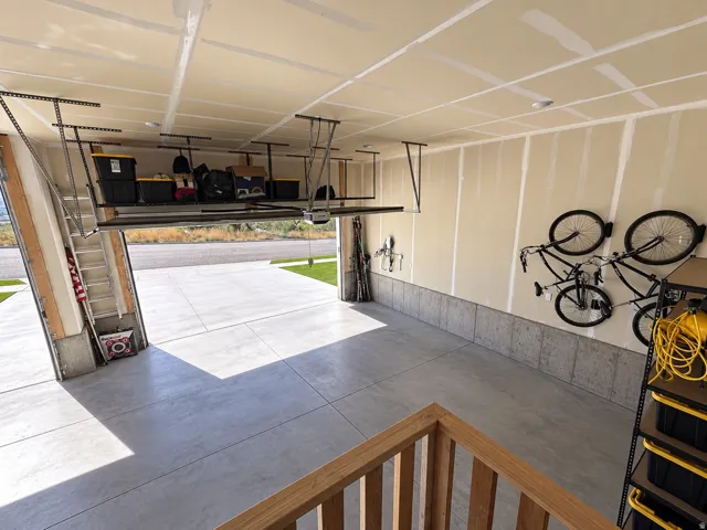Attached garage featuring a concrete floor, built-in overhead storage racks, and wall-mounted bike storage