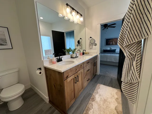 Dual sink vanity with wood-finish cabinetry and matte black hardware