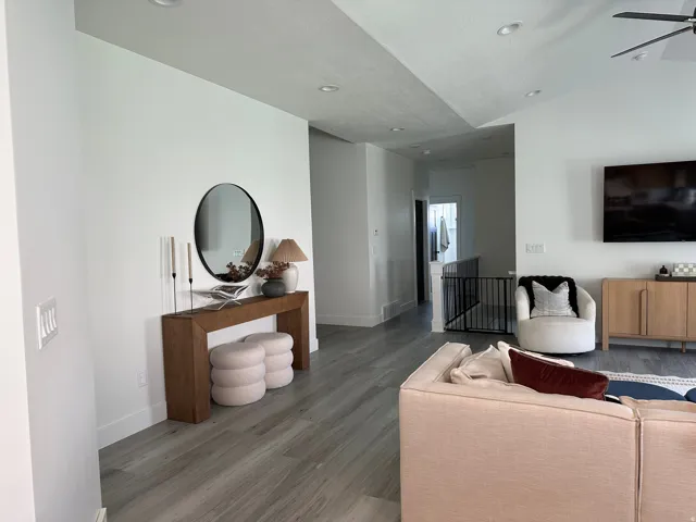Recessed lighting, light wood-finish flooring, white walls, and a contemporary console table