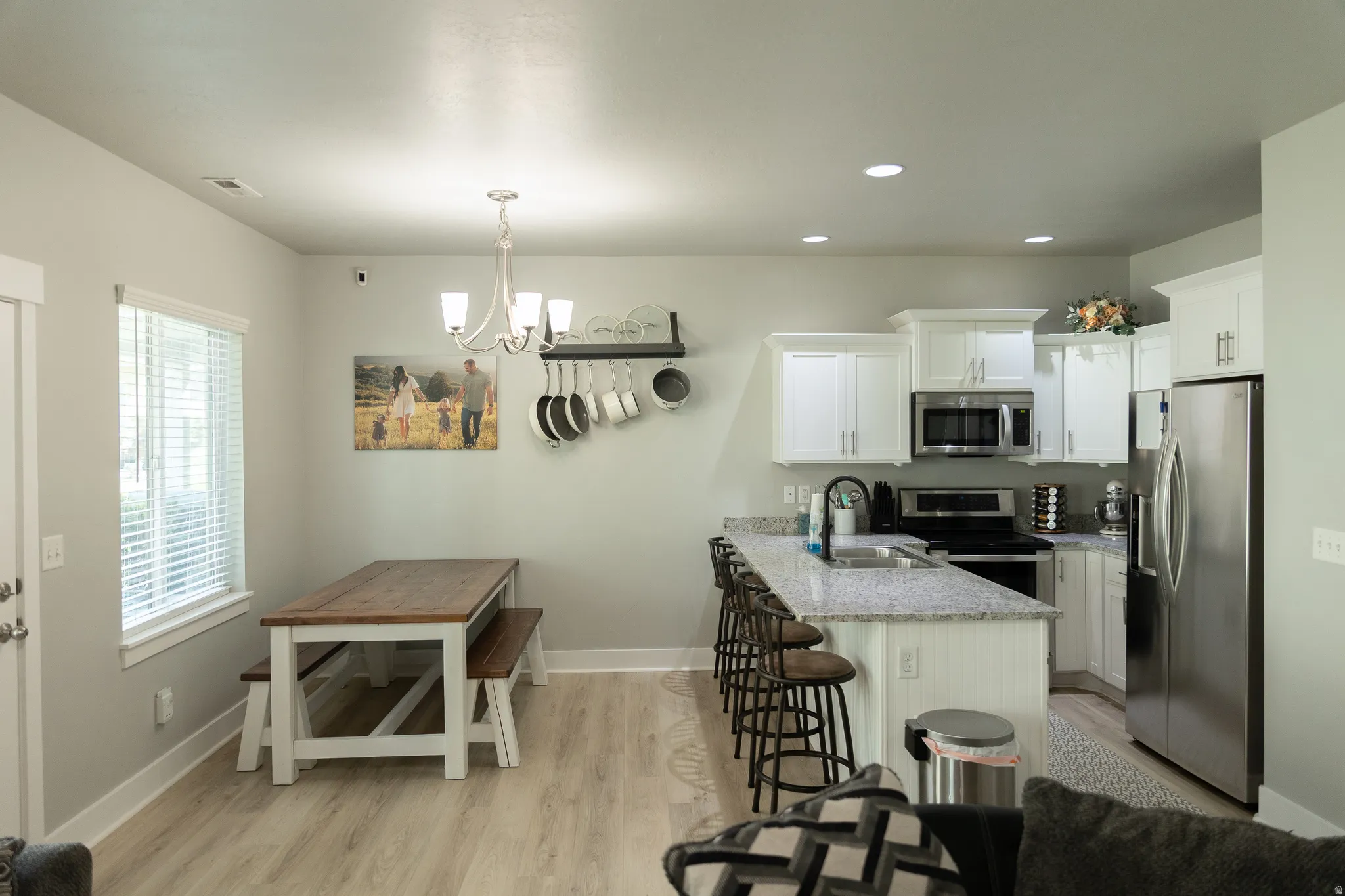 Open-concept kitchen with white cabinetry and stainless steel appliances