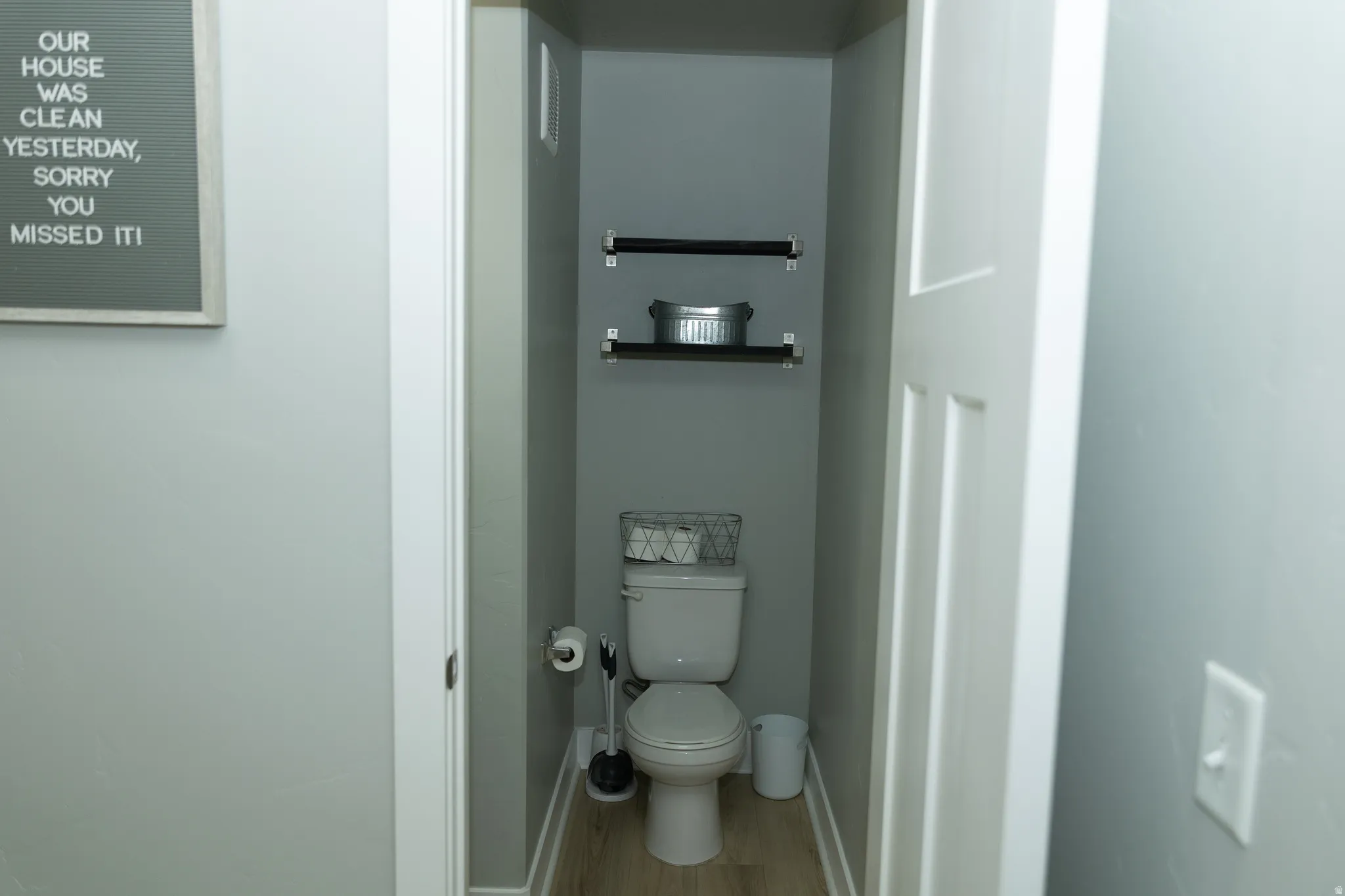Half bathroom with wood floating shelves