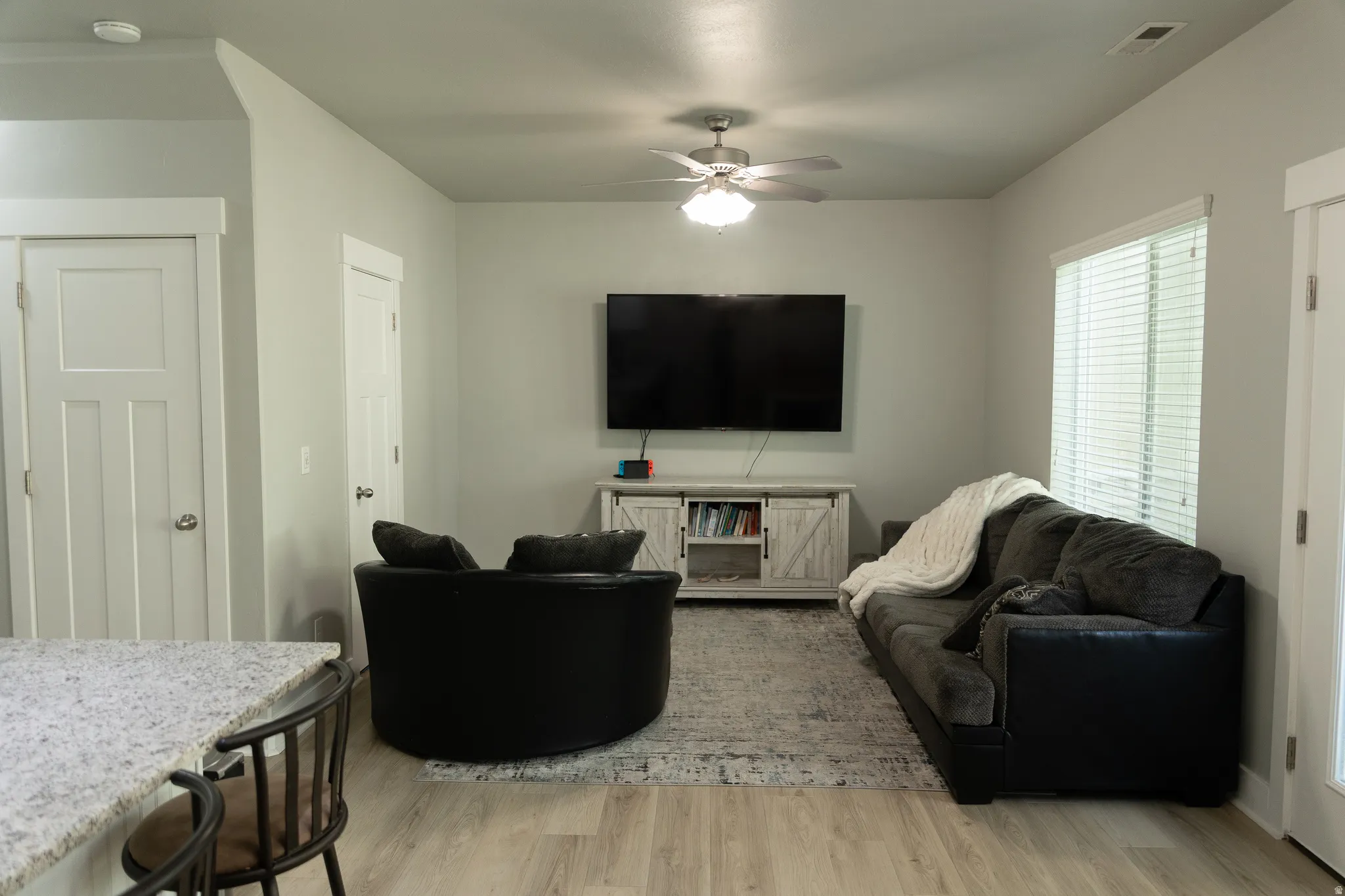 Recessed lighting, wood-finish flooring, ceiling fan with light fixture, and white window blinds
