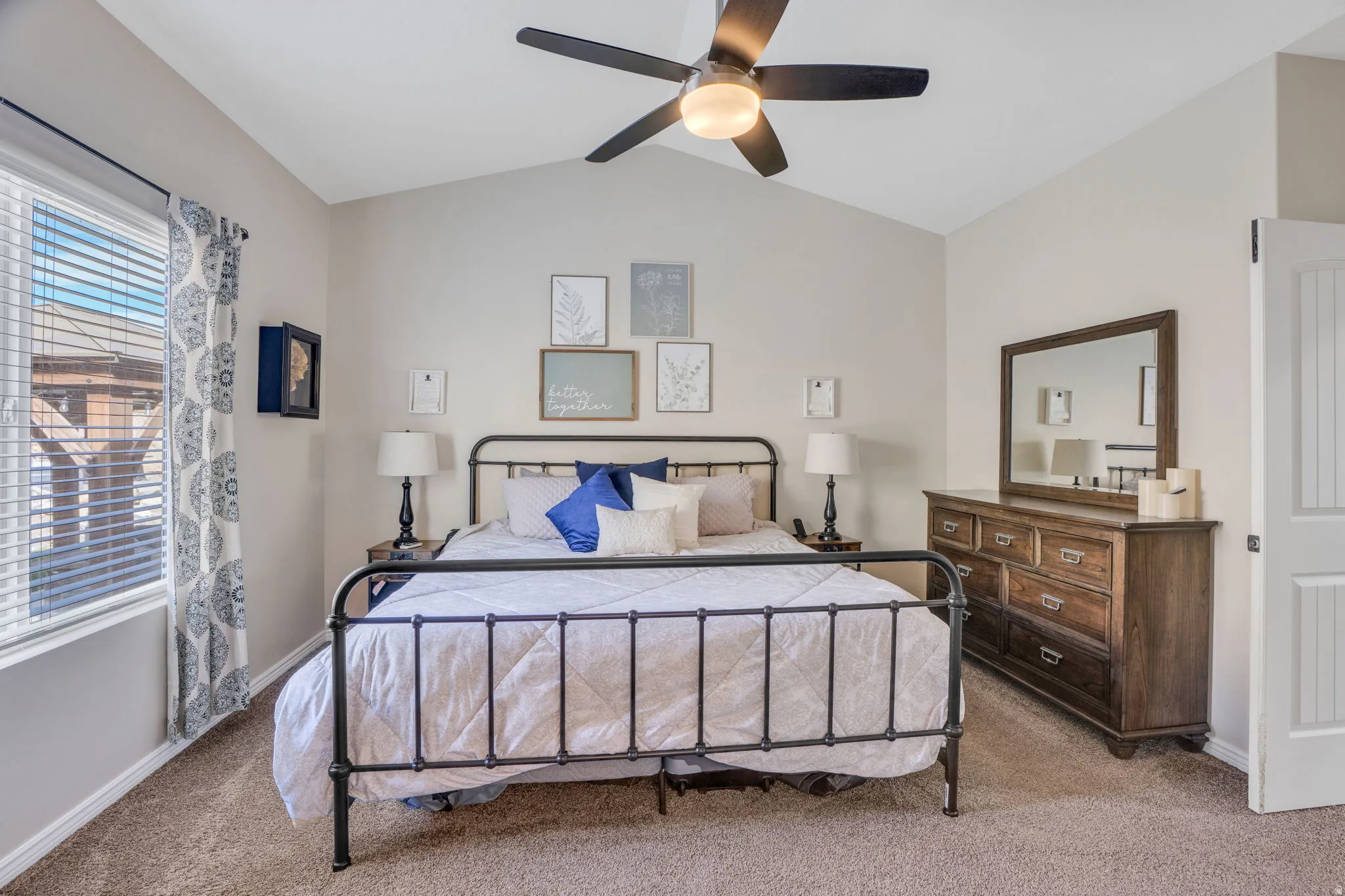 Vaulted ceiling with a ceiling fan, window with blinds, and carpeted flooring