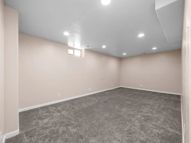Recessed ceiling lighting, textured wall finish, and a window opening