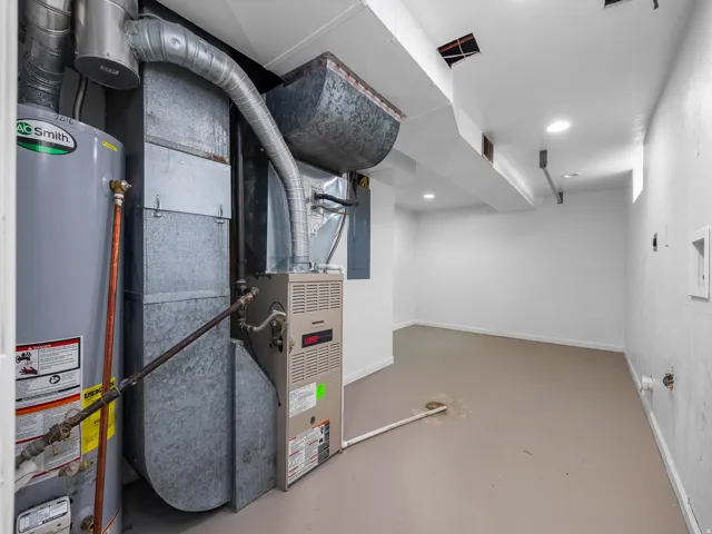 Finished basement utility space featuring a water heater, furnace, and recessed lighting