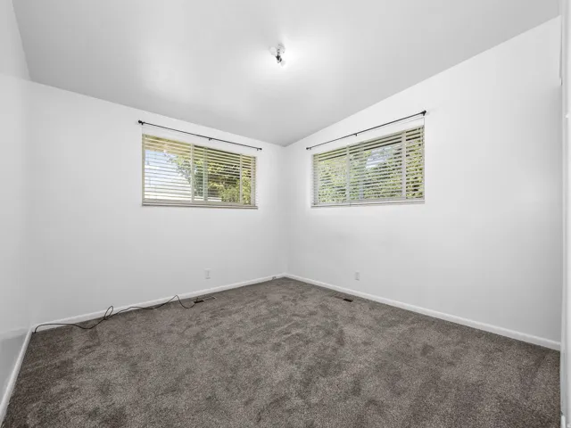 Neutral wall paint with two windows featuring horizontal blinds