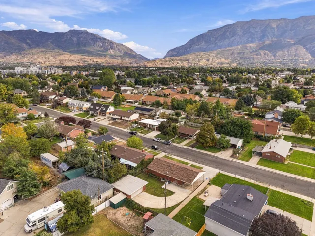Residential neighborhood with mature trees, established landscaping, and mountain scenery
