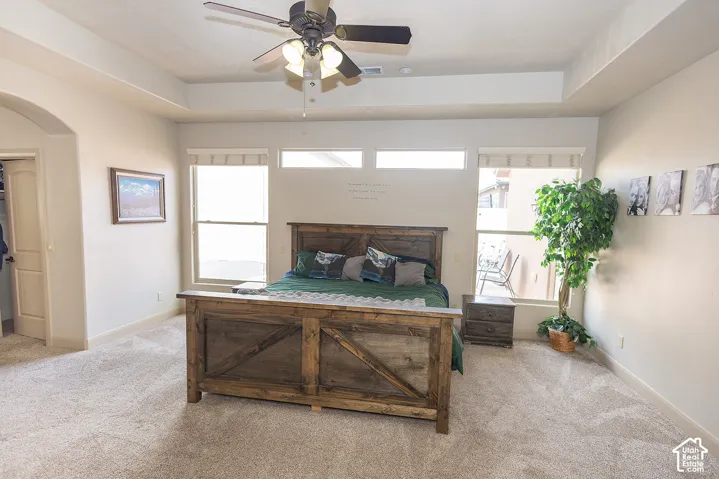 Recessed ceiling with a ceiling fan, light-colored walls, and carpeting