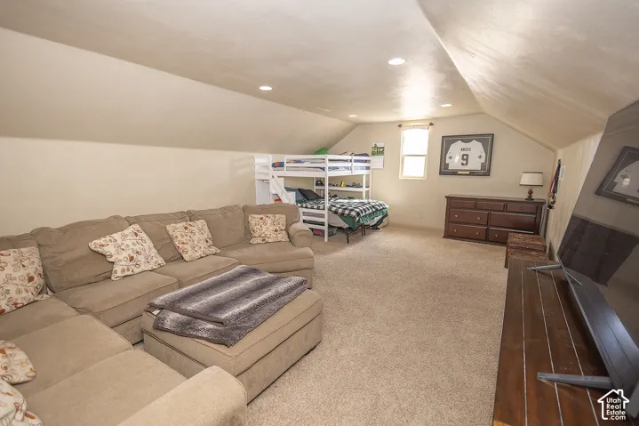 Carpeted loft space featuring recessed lighting and a window