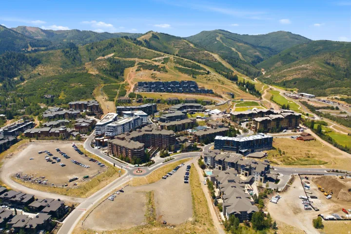 Development featuring multiple residential buildings and a mountainous backdrop