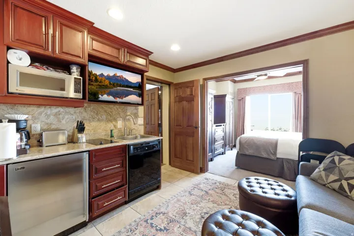 Compact kitchen featuring wood-finish cabinetry, granite-style countertops, and a tile backsplash