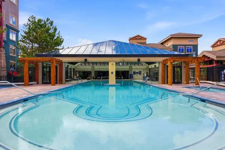 Outdoor swimming pool featuring integrated steps and a mosaic tile design