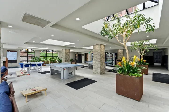 Spacious common area featuring light-toned tile flooring, recessed lighting, and skylights