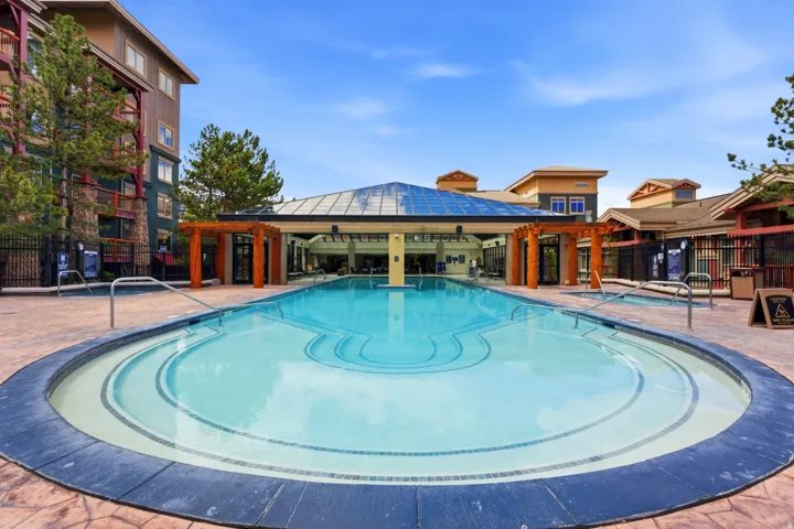 Expansive outdoor swimming pool with a distinct curvilinear shape and integrated spa