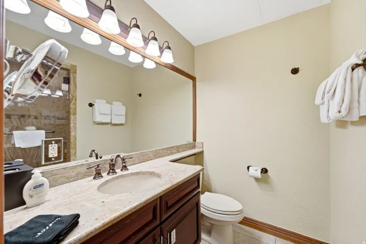 Vanity with a light-toned countertop, integrated sink, and dark wood-finish cabinetry