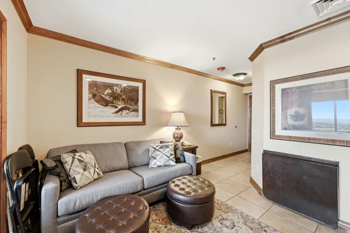Wall-mounted folding table, crown molding, tile flooring, recessed lighting, and a neutral color palette