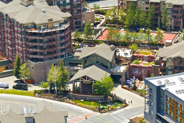 Multi-story residential complex featuring stone and wood-finish siding