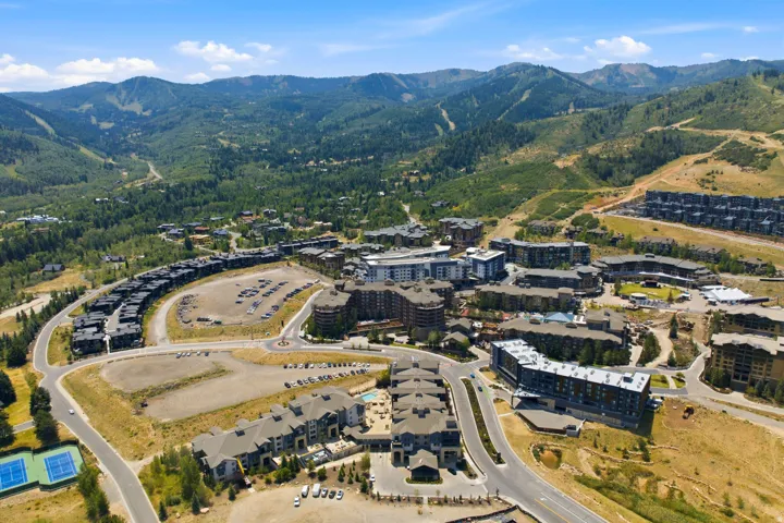 Aerial perspective showcasing multi-story residential structures and surrounding mountainous terrain