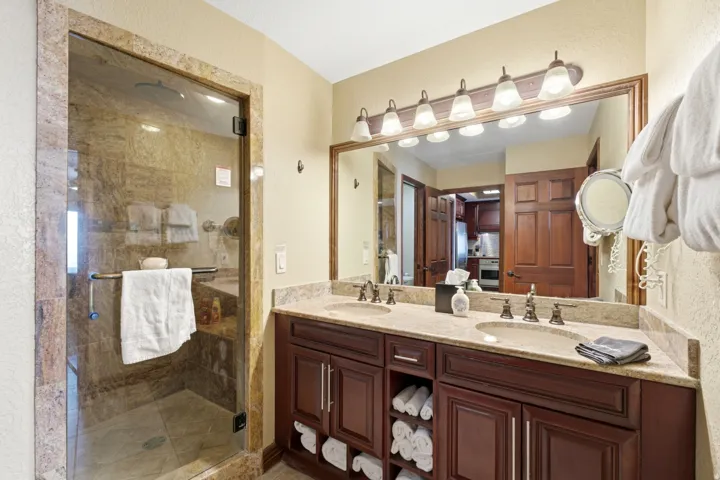 Double vanity with integrated sinks, dark wood cabinetry, and a light-toned countertop