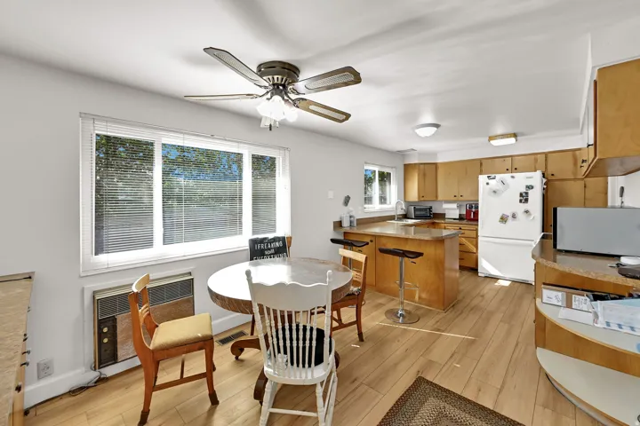 Kitchen with wood-finish flooring, light wood cabinetry, and a peninsula countertop