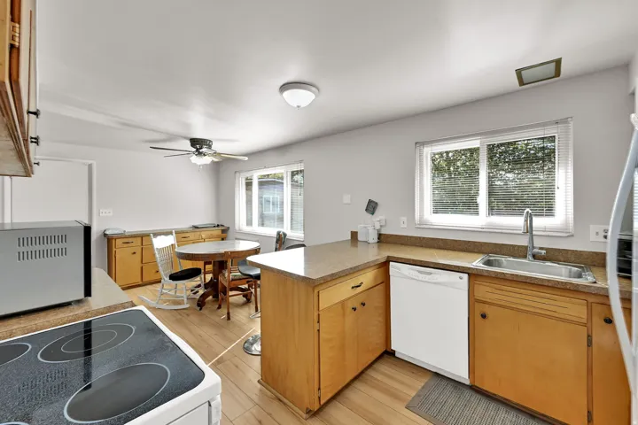 Kitchen featuring wood-finish flooring, wood cabinetry, and a double basin stainless steel sink