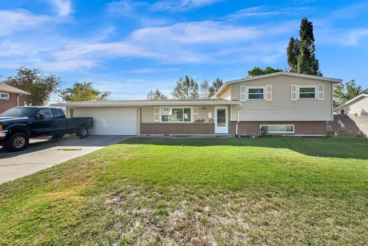 Split-level residence featuring a two-car garage, concrete driveway, and full-light entry door