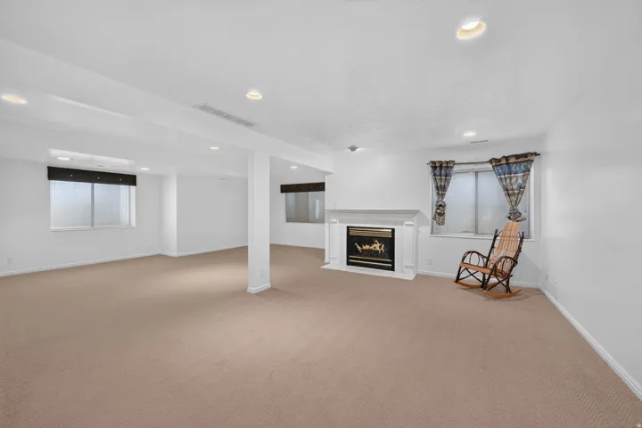 Expansive room with neutral carpet, recessed lighting, and multiple windows