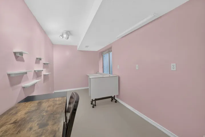 Recessed window, track lighting, and a fluorescent overhead light fixture complement the light-colored flooring