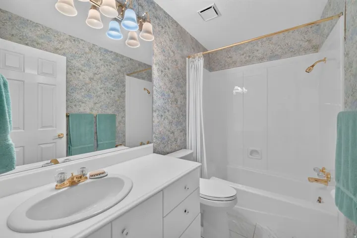 White vanity with an oval sink and gold-finish faucet