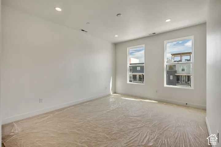 Recessed lighting, light-colored walls, and two large windows