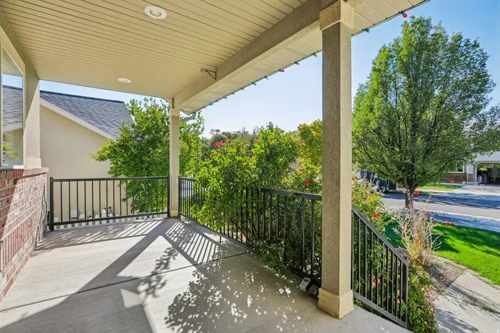 Covered front porch with concrete flooring and recessed lighting