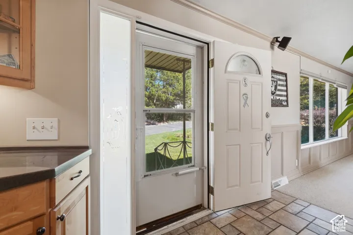 Entryway with storm door.  Enters into kitchen and front room.