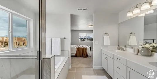 Dual vanity with white cabinetry, ample countertop space, a built-in bathtub with tile surround, and a clear glass shower enclosure. This home is to be built. Pictures are of a similar home.