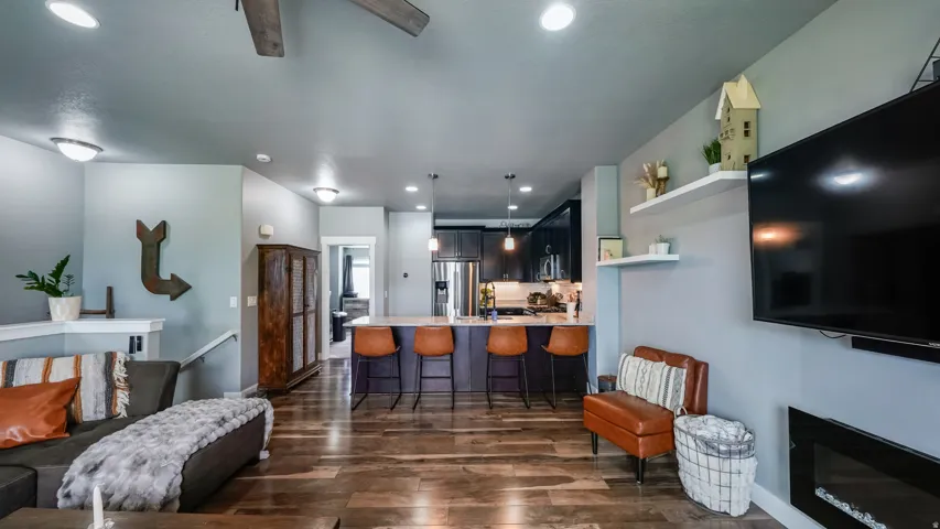 Open-concept living area featuring wood-finish flooring, recessed lighting, and a built-in electric fireplace