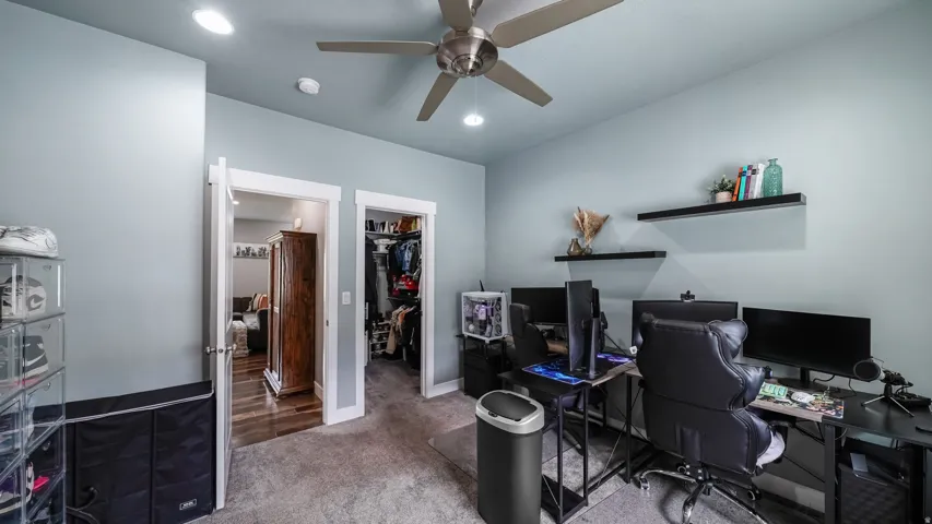 Recessed lighting, ceiling fan, two open doorways, and floating wall shelves