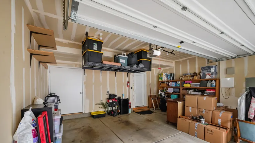 Garage interior featuring a concrete floor and exposed wall studs