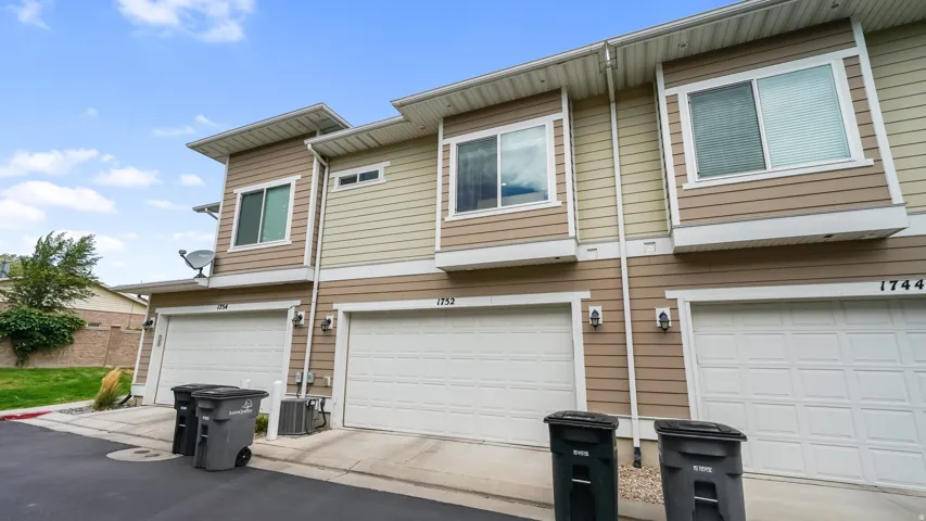 Multi-level exterior with horizontal siding and integrated garage doors