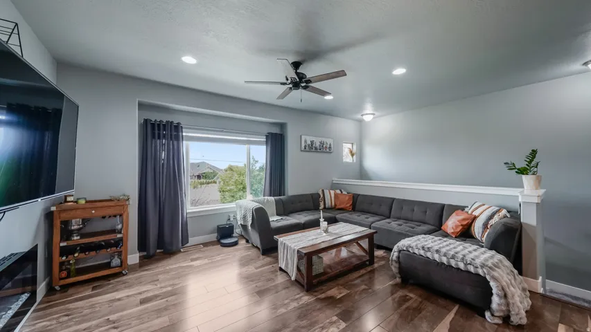 Living area featuring wood-finish flooring, recessed lighting, and a ceiling fan