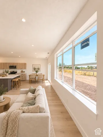 Open-concept living space featuring wood-finish flooring, recessed lighting, and a large multi-pane window