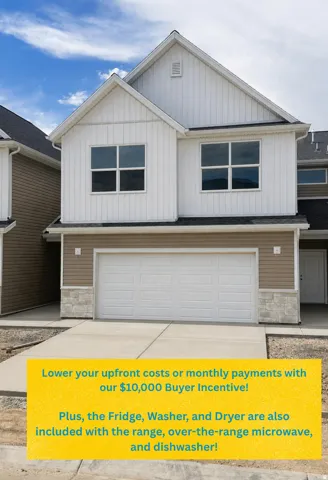 Two-story residence featuring white vertical siding, tan horizontal siding, stone accents, a two-car garage, and a concrete driveway