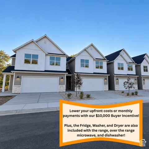 Modern residential units featuring white and gray siding, attached garages, and concrete driveways