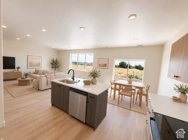 Open-concept living space with wood-finish flooring, recessed lighting, a kitchen island with an integrated sink and stainless steel dishwasher, and a dining area with a sliding glass door