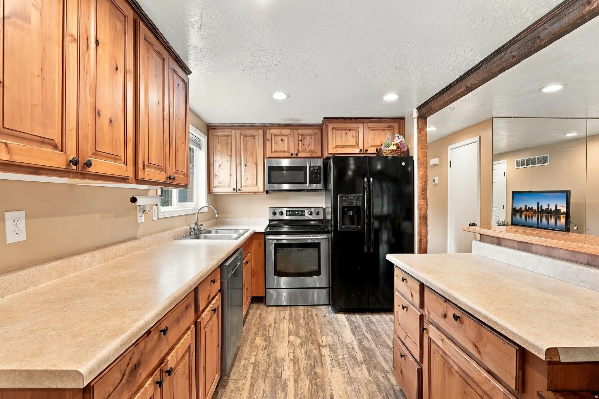 Wood-finish flooring with wood cabinetry and light-toned countertops