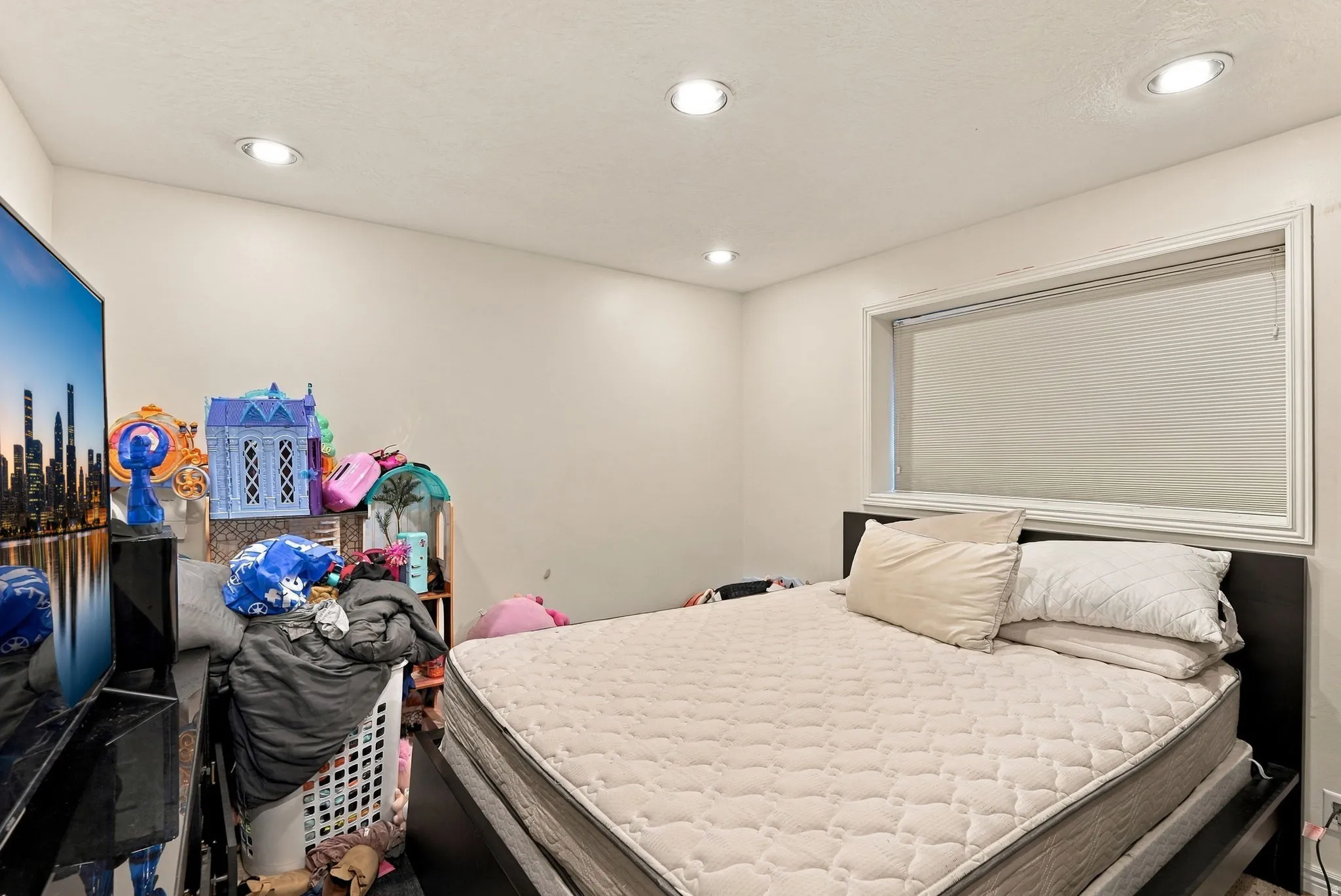 Recessed lighting, a window with white trim, and light-colored walls
